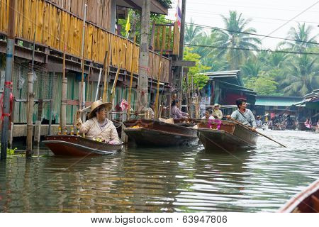 RATCHABURI, THAILAND - MARCH 24: Local peoples sell fruits, food and souvenirs at famous tourist attraction Damnoen Saduak floating market on March 24, 2014 in Ratchaburi, Thailand.