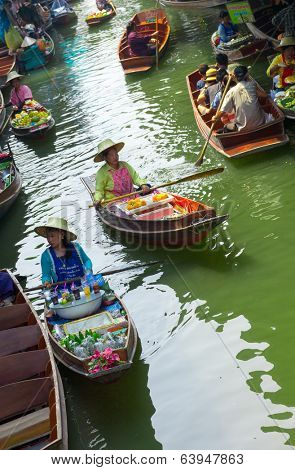 RATCHABURI, THAILAND - MARCH 24: Local peoples sell fruits, food and souvenirs at famous tourist attraction Damnoen Saduak floating market on March 24, 2014 in Ratchaburi, Thailand.