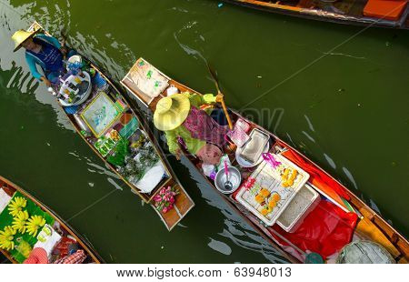 RATCHABURI, THAILAND - MARCH 24: Local peoples sell fruits, food and souvenirs at famous tourist attraction Damnoen Saduak floating market on March 24, 2014 in Ratchaburi, Thailand.