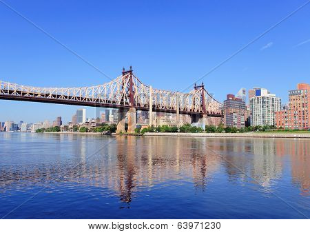 Queensborough Bridge in Midtown Manhattan with New York City skyline over East River as the famous landmarks viewed from Brooklyn.