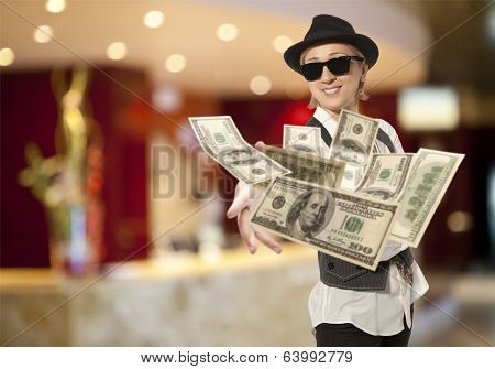 Handsome adult business woman in cap throwing dolla
