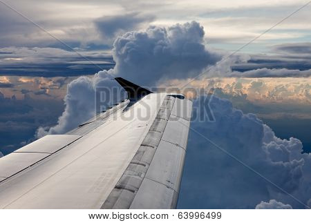 Airplane Above Clouds In The Sky