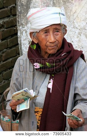 MINGUN, MYANMAR - DECEMBER 30: Unidentified woman (portrait) sells groceries on a street on December