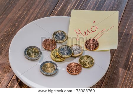 a plate of coins for tipping or charge for toilets. in french