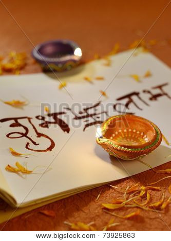 Indian traditional lamps placed on a book with Sanskrit calligraphy