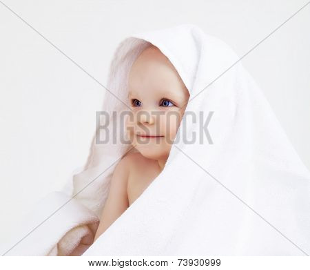 happy baby with a towel after the shower in bed at home