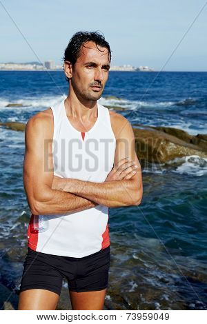Exhausted fit runner after workout resting on seaside