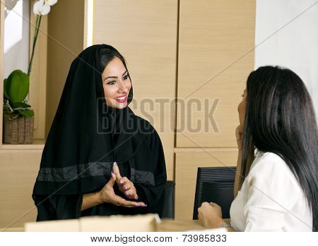 Arabian Receptionist helping a customer on the front desk
