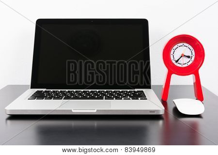 Laptop And Red Clock  On Black Wooden Table