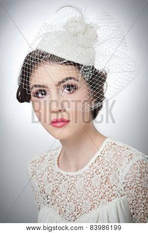 Hairstyle and make up - beautiful young girl art portrait. Cute brunette with white cap and veil