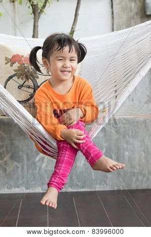 Portrait Of Children Toothy Smiling And Relaxing In Clothes Cradle At Home Living Terrace