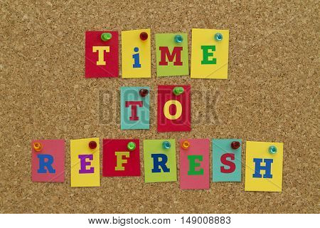 TIME TO REFRESH message written on colorful sticky notes pinned on cork board.
