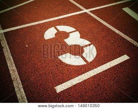 Number Three. White Track Number On Red Rubber Racetrack,