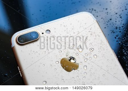 PARIS FRANCE - SEP 26 2016: New Apple iPhone 7 Plus unboxing and testing - rain drops on back of the phone. New iPhone7 is one of the best waterproof smart phone in the world