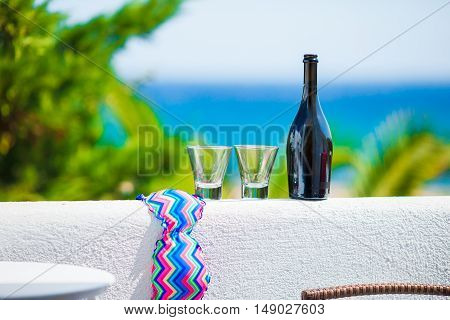 Glass and bottle of tasty red wine on balcony