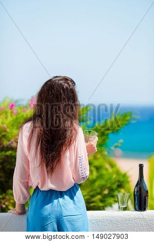 Glass and bottle of tasty red wine on balcony