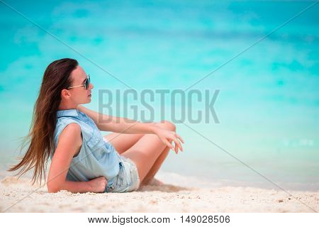 Young beautiful woman during tropical beach vacation. Enjoy suumer vacation alone on the beach at Africa with frangipani flowers in her hair