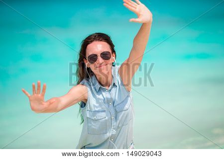 Young beautiful woman during tropical beach vacation. Enjoy suumer vacation alone on the beach at Africa with frangipani flowers in her hair