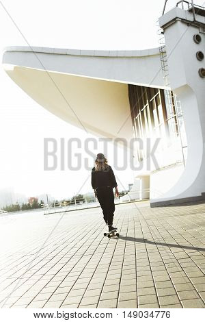 Young Hipster Teanage Girl Rides A Longboard In An Urban Environment. Active Lifestyle