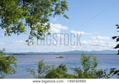 Summer landscape with river and trees along the edge