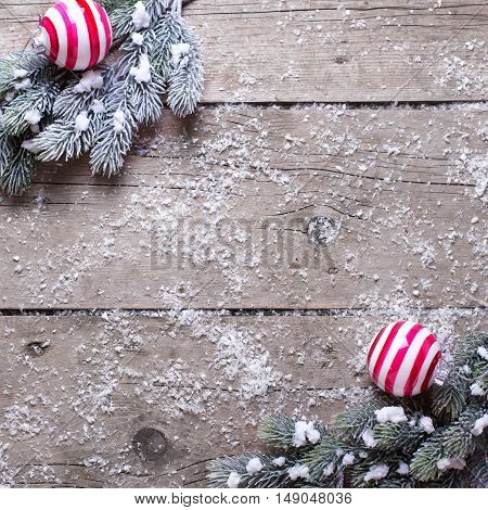 Christmas balls and branches fur tree on aged wooden background. Decorative christmas composition. Selective focus. Place for text. Square image.