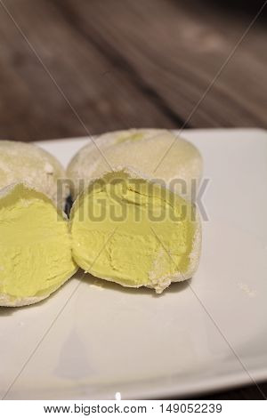 Green tea mochi ice cream bonbon desert on a white plate