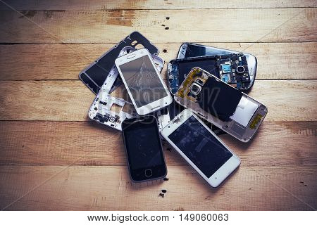 Broken smart phone with space in wooden texture background