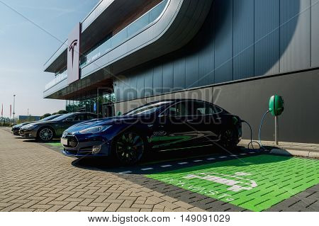 TILGURG, NETHERLANDS - SEPTEMBER 25, 2016:  Black Tesla Model S electric car is being charged at Tesla Supercharger Station of Tilburg, Netherlands.