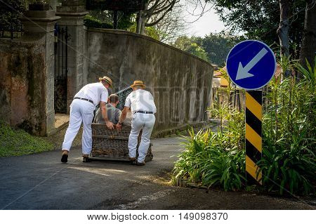 Traditional sledge downhill attraction in Monte garden. Sledges going down on the asphalt streets of Funchal. Madeira island, Portugal
