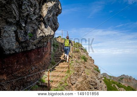 Tourist is going uphill by steep steps in the mountains of Madeira island. Pico Arieiro, Portugal.