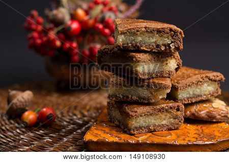 Fresh Dutch filled spicy cookies with almonds on autumn colored and dark background