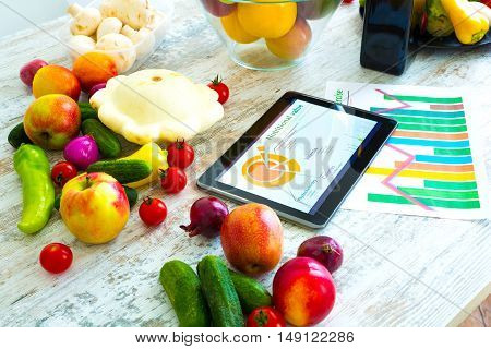 Organic food and a Tablet PC showing information about healthy nutrition and phytochemical composition.