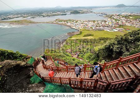 Jeju Island - 5 October 2014: High angle view of international tourists and landscape image from top of crater Jeju Volcanic as "Seongsan Ilchulbong tuff cone" at Jeju Island,South Korea.