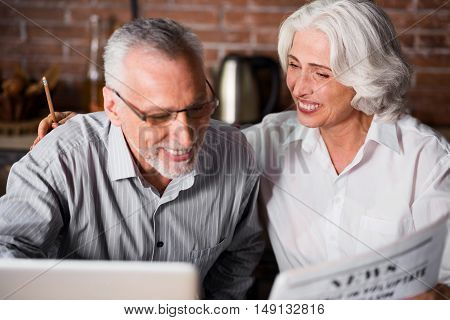 Forever in love. Woman in her 60s smiling at her husband while hugging him