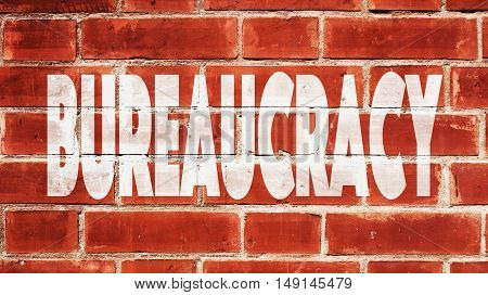 Bureaucracy Written On A Red Brick Wall.