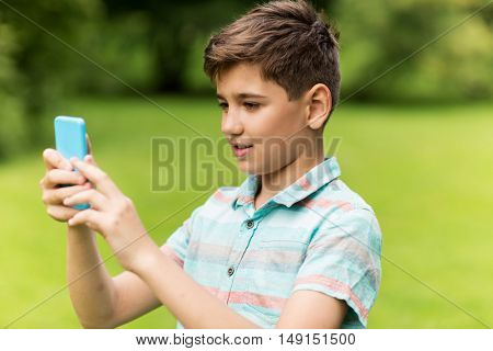 childhood, augmented reality, technology and people concept - boy with smartphone playing game in summer park