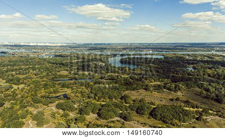 Panoramic view of the Kiev suburb from above. Aerial view. Outdoor. Beautiful photos of nature with fields river and reservoirs with high-rise buildings in the background.