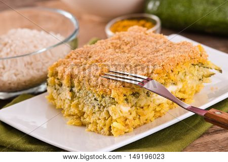 Rice timbale with zucchini on wooden table.