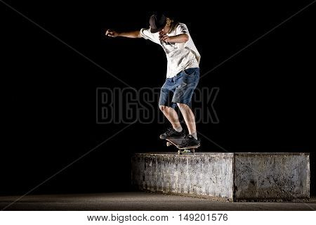 Boy doing skateboard trick nosegrind on night