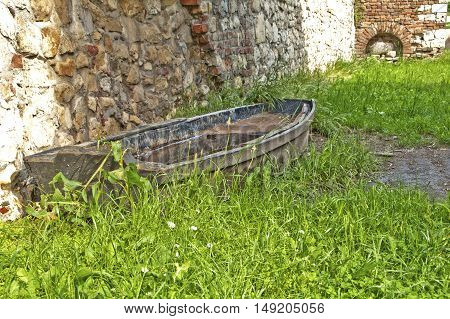 One abandoned wreck wooden boat strand in the grass