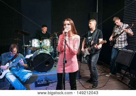 Musical band performance, hobby, leisure. Group of young adults playing music in studio. Hobby, leisure, pastime concept