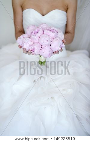 Beautiful bride is holding a wedding colorful bouquet. Beauty of colored flowers. Close-up bunch of florets. Bridal accessories. Female decoration for girl. Details for marriage and for married couple