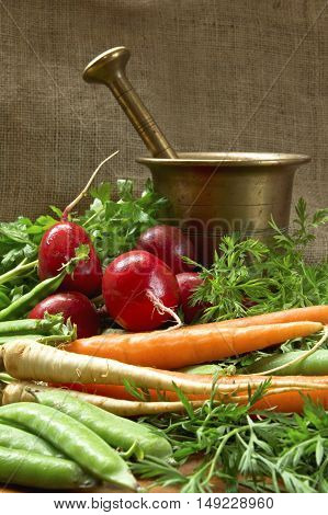 Tasty fresh vegetables with old bronze mortar.