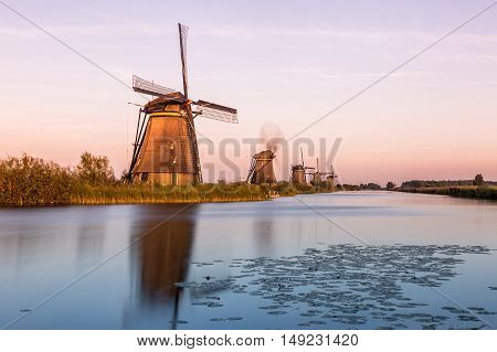 Windmills of Kinderdijk near Rotterdam in Netherlands. Colorful spring scene in the famous Kinderdijk canals with windmills, UNESCO world heritage site