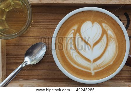 hot milk art coffee on wooden plate