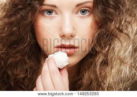 beauty portrait of a cute  girl in act to eat a candy with cocoanut