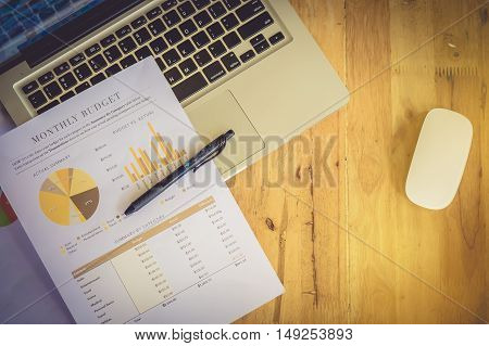 stock market chart pen mouse and laptop on wood desk. vintage effect. selective focus. release concept.