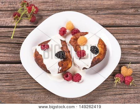 Delecious cheese-and-curd cake with fruits on the old wooden surface