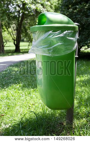 Empty green trash bin in the park.