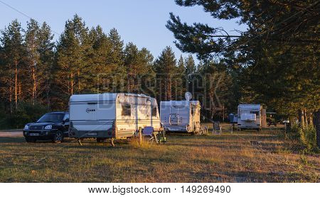MEDELPAD, SWEDEN ON JULY 09. View of a campsite, car, campers and caravan on July 09, 2016 by Holmsjon, Sweden. Late evening after a sunny day. Pine forest. Editorial use.